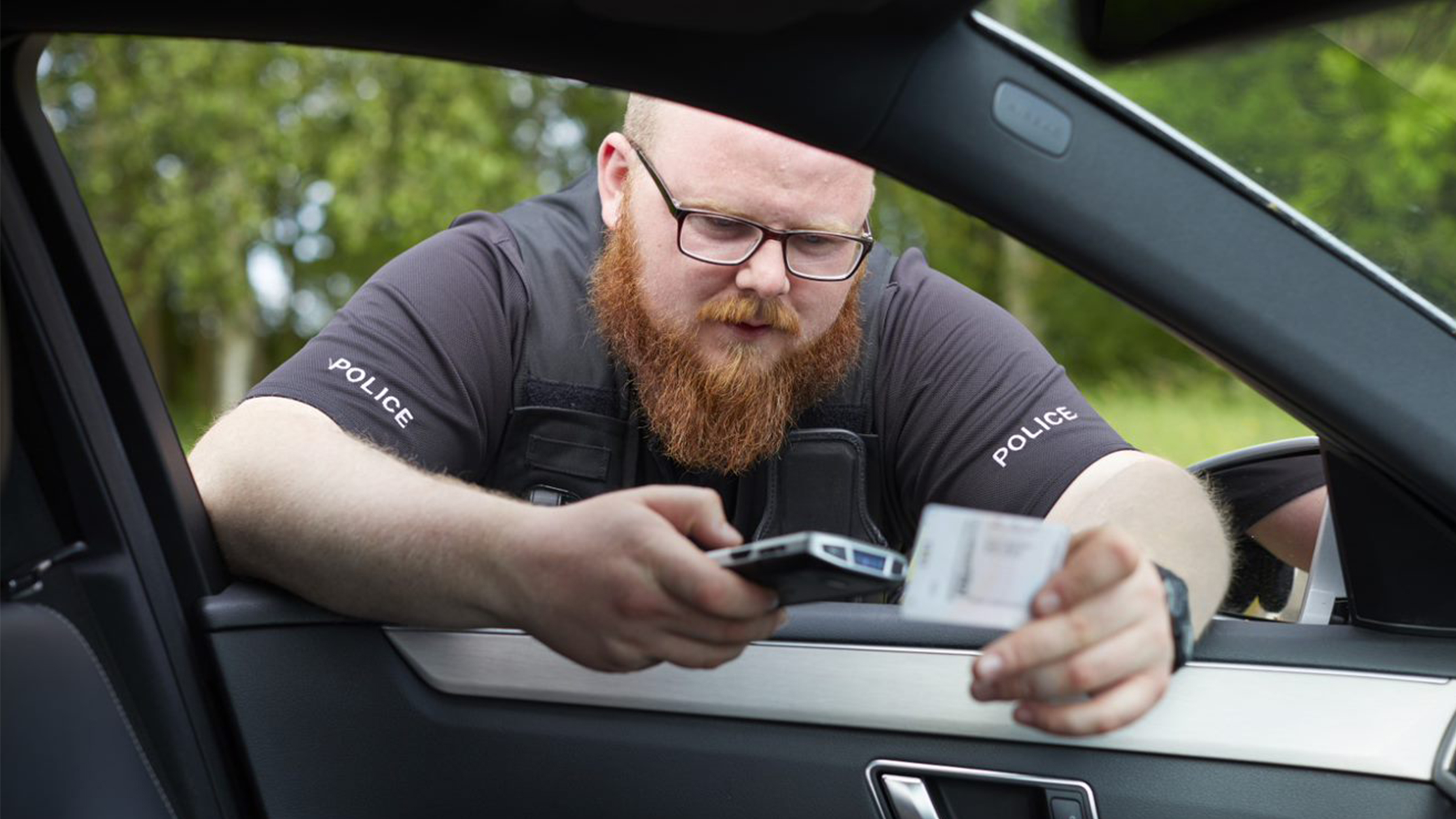public sector photography website police officer handheld in hand checking driver licence